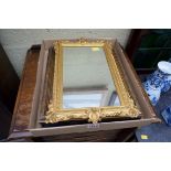 Two small gilt framed wall mirrors; together with another.