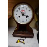 An old oak balloon mantel clock, with white enamel dial, 31.5cm high, with winding key.