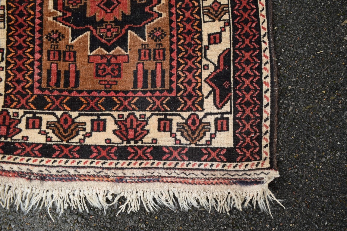 A Baluch prayer rug, with two large medallions on a plain field with geometric motifs, 141 x 82cm. - Image 6 of 8