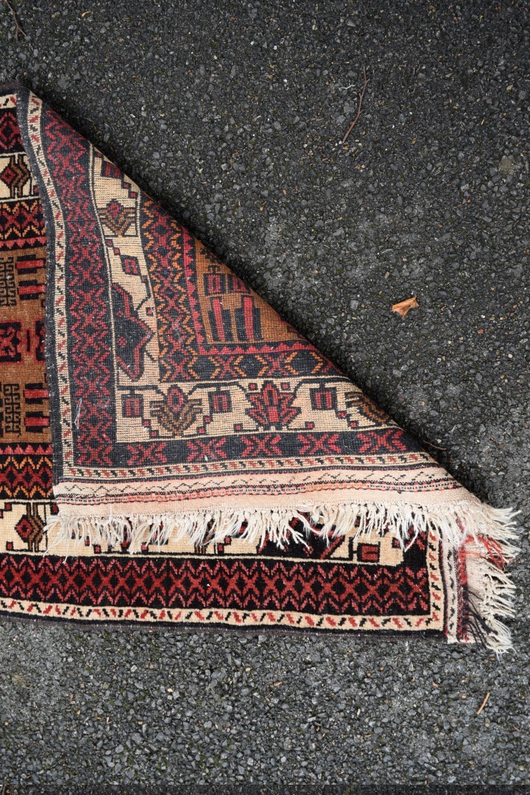 A Baluch prayer rug, with two large medallions on a plain field with geometric motifs, 141 x 82cm. - Image 8 of 8