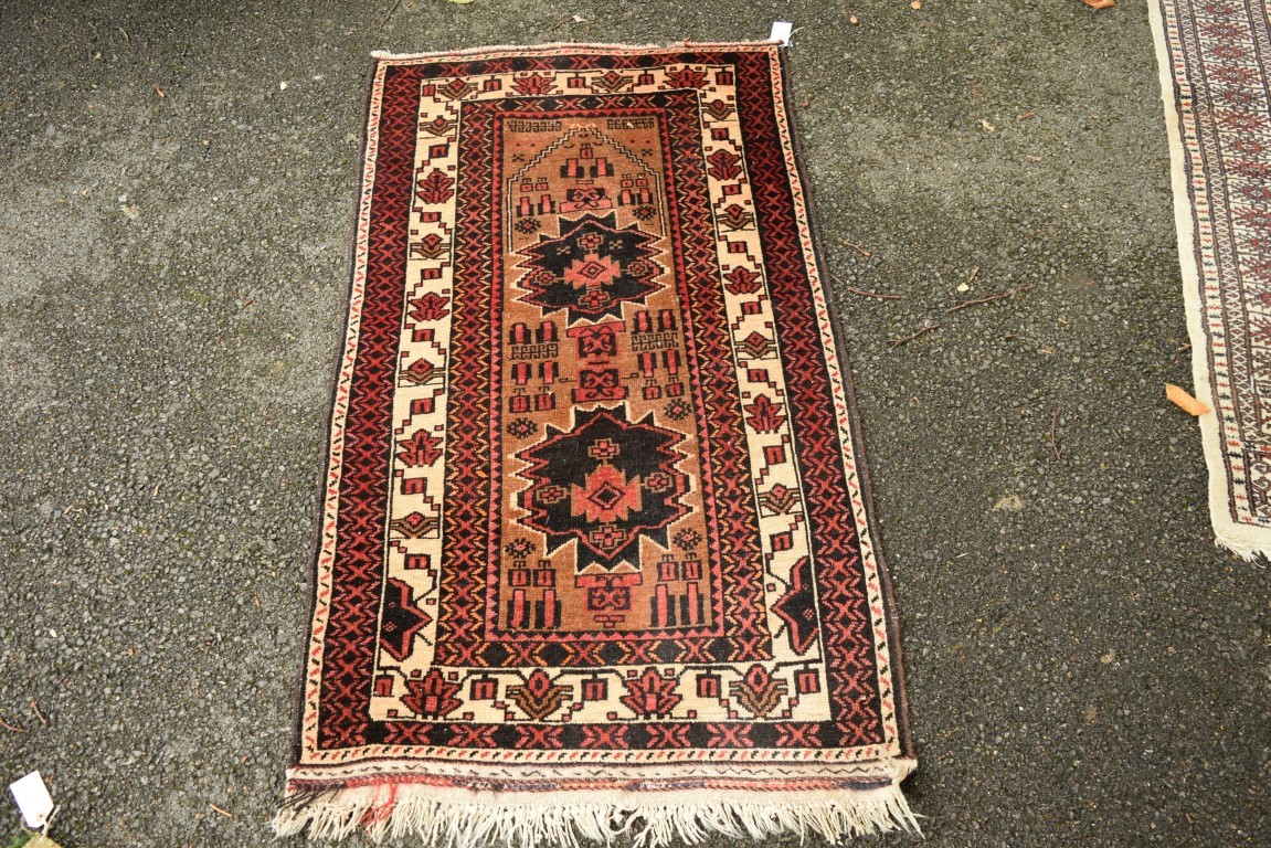 A Baluch prayer rug, with two large medallions on a plain field with geometric motifs, 141 x 82cm.