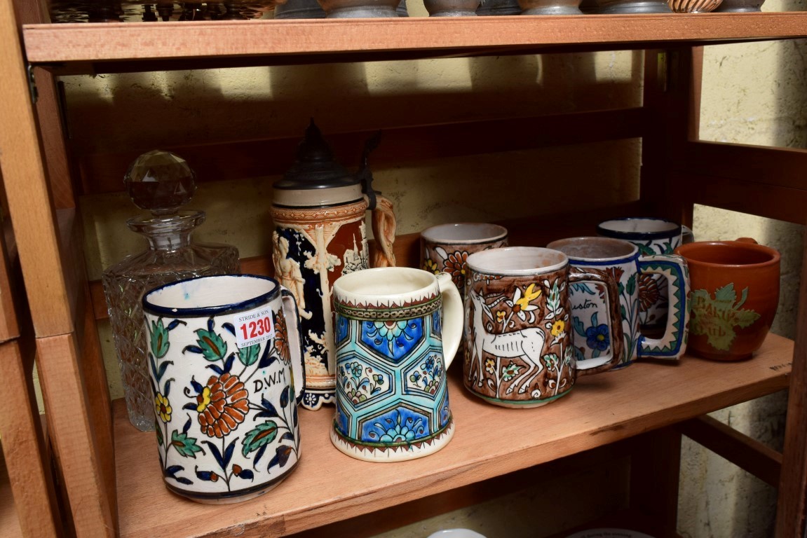 Seven Iznik and Jerusalem mugs; together with a stein; and a clear glass decanter and stopper.