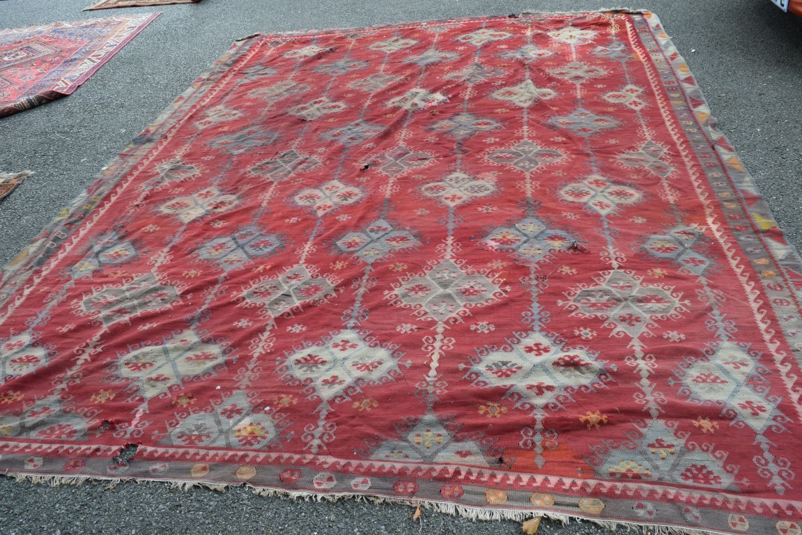 A large Turkish flat weave kelim carpet, with an all over geometric lattice design on a red field,