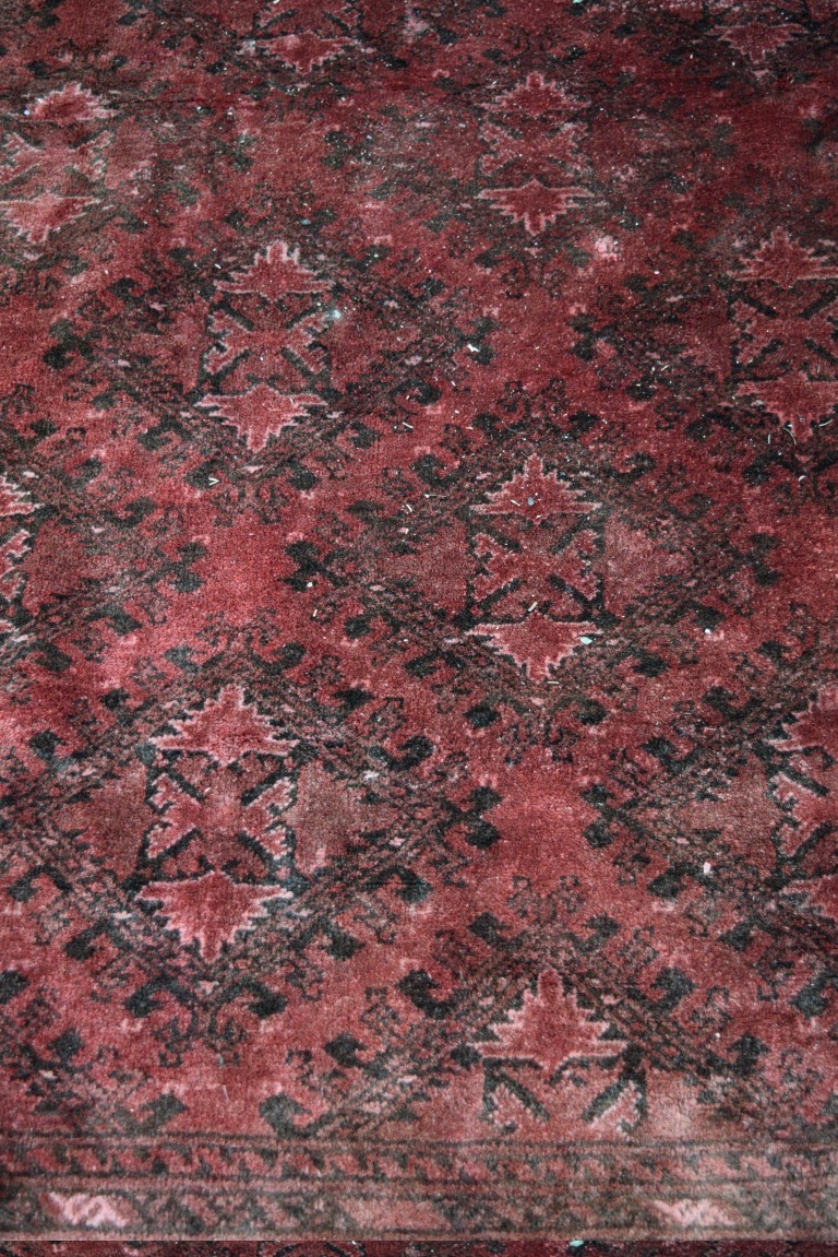 An Afghan carpet, with an all over diamond medallions on a red field, - Image 2 of 4