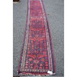 A narrow Turkish runner, with all over stylized floral design on a blue field, 285 x 55cm.