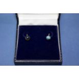 A pair of unmarked gold ear studs set central emerald;