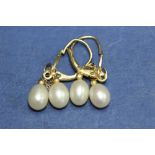 A pair of 9ct gold double pearl pendants earrings; together with another pair set in silver.