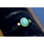 An 18ct gold ring set cabochon opal with diamond to each shoulder.