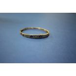 A late Victorian 9ct gold sapphire and diamond bangle.