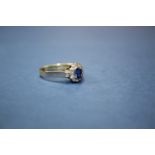 A 14k gold ring set central oval sapphire surrounded by diamonds.