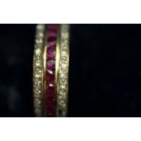 An 9ct gold inline ruby and diamond half hoop ring (not 18ct as originally stated).