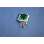 A contemporary 18ct gold ring set rectangular emerald doublet surrounded by brilliant cut diamonds.