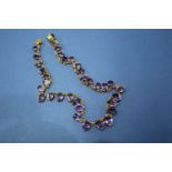 An unmarked necklace set 34 claw set oval amethysts, 38cm.