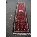 A Persian Hamadan runner,with central medallions on a Herati red field, 285 x 76cm.