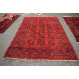 An Afghan carpet, with 3 x 6cm Gul design and a red field.