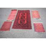 An Afghan three Gul red rug, together with a narrow Afghan runner and three Afghan mats.