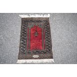 A Pakistan prayer rug, with signature cartouche to lower centre field, 90 x 64cm.