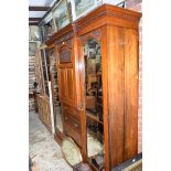 A circa 1900 carved walnut compactum wardrobe, with mirrored central door, 186cm wide.