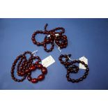 Two graduated cherry amber bead necklaces; together with a smaller example.