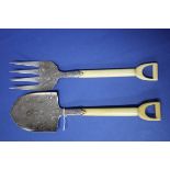 A pair of silver plated novelty fork and spade fish servers, having ivory handles, 19cm.