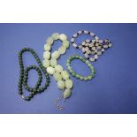 Three various coloured jade necklaces; together with a jade bracelet.