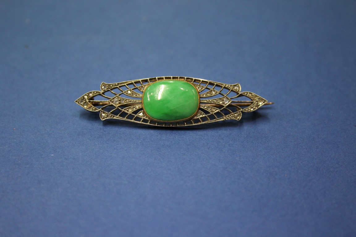 An Edwardian unmarked brooch set cabochon jade and mine cut diamonds.