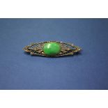 An Edwardian unmarked brooch set cabochon jade and mine cut diamonds.