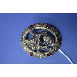 A silver gilt and almandine set brooch,