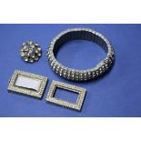 An expanding metal bracelet; together with a brooch; and a diamante buckle.