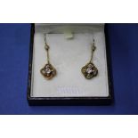 A pair of unmarked yellow metal pendant earrings, each set a solitaire diamond.