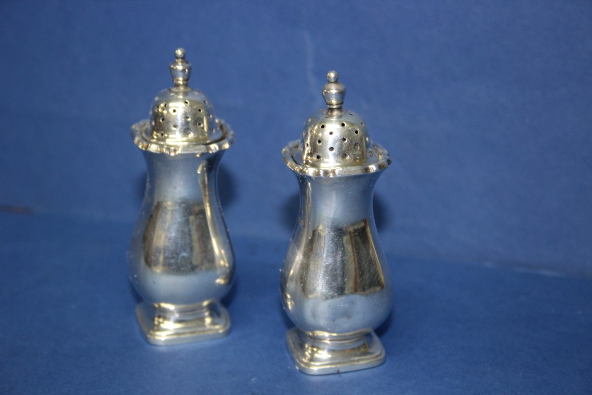 A pair of silver pepperettes, by S Ltd, Birmingham 1930 and 1932, 68g.