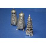 An Oriental white metal pagoda pepper and a pair of similar Siamese examples.