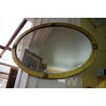 A hammered brass framed oval wall mirror, 83 x 57cm.