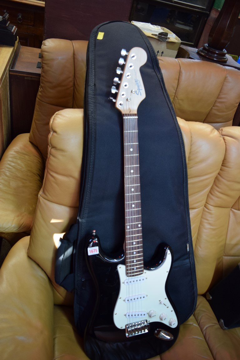 A Fender Squier Strat electric guitar, in padded bag; together with Squier SP10 amp.