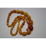 An amber necklace, of fifty five graduated oval beads, 70cm long, 46g.