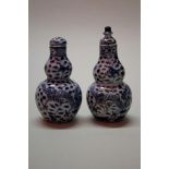 A pair of Chinese miniature double gourd vases and covers, each painted with a pair of dragons,