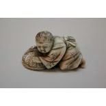 A Japanese carved ivory netsuke of a kneeling boy with a basket, Meiji period,