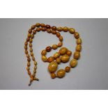 An amber bead necklace, of fifty nine graduated oval beads, 78.5cm long, 42g.