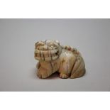 A Japanese carved ivory netsuke of a lion dog, Meiji period, 4.