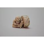 A Japanese carved ivory netsuke of a boy and drum, signed Shiko, 19th century, 3cm high.