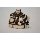 A Japanese carved ivory netsuke of a man with an ox, Meiji period, 3.8cm wide.