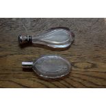 Two cut glass perfume flasks, having metal caps.