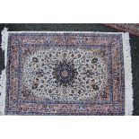 A machine made floral design rug, having central red star medallion on ivory field.