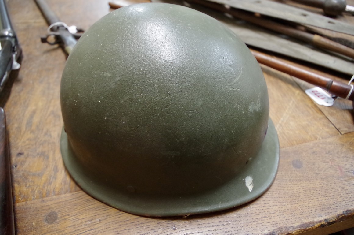 An old green painted military tin helmet.