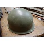 An old green painted military tin helmet.
