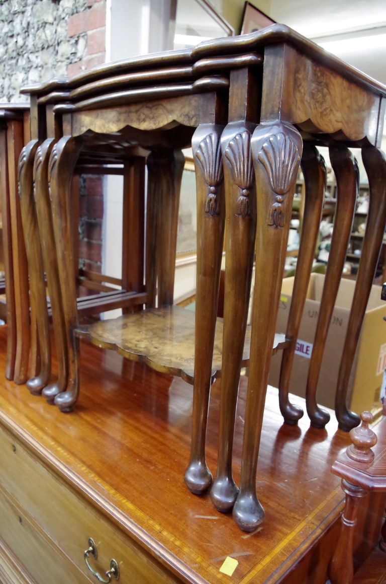 A nest of three figured walnut tables, largest 57.5cm wide.