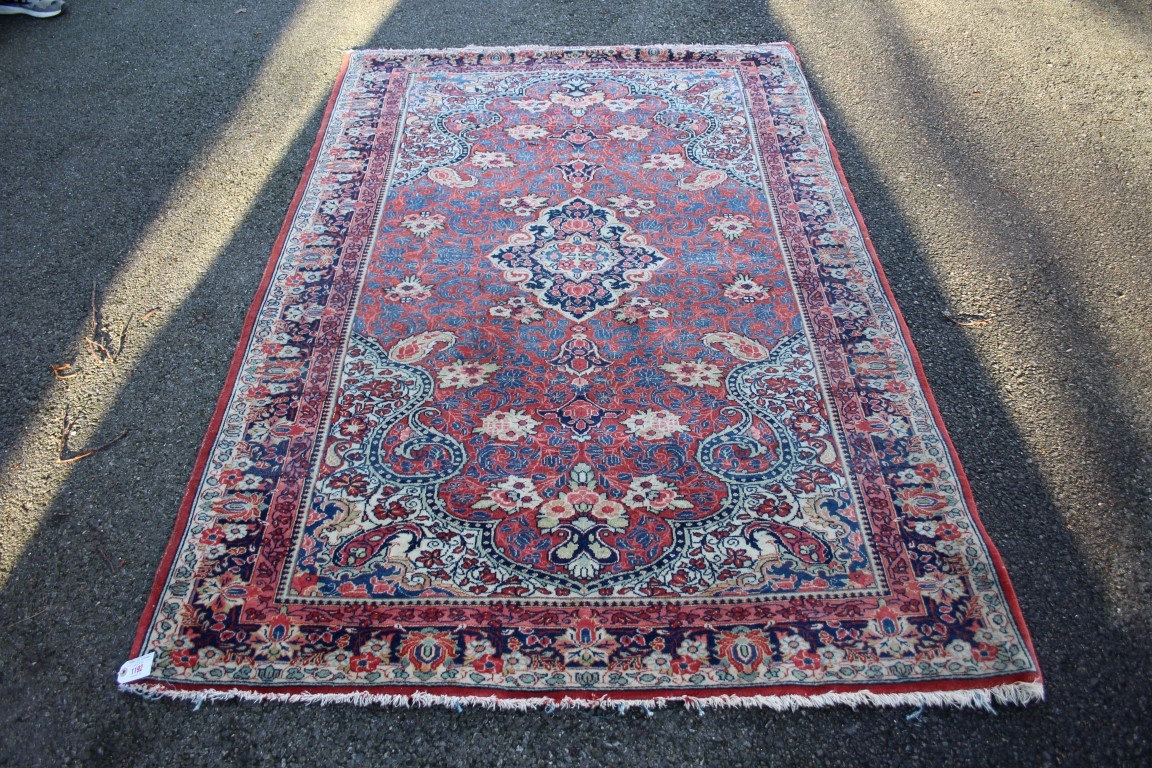 A Persian Saruq rug, having central medallion on red floral field.