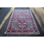 A Persian Saruq rug, having central medallion on red floral field.