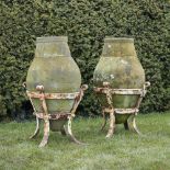A pair of pottery storage jars 19th century on substantial wrought iron stands104cm.; 41ins high