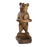 Hall furniture: A black forest carved walnut stick stand in the form of a bear,late 19th century